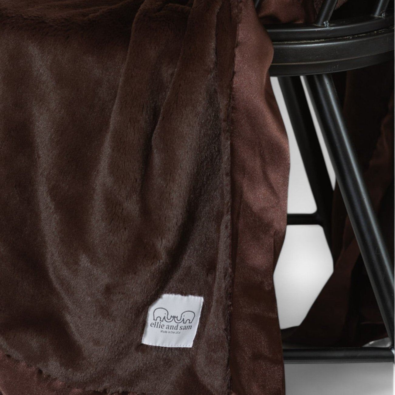 Chocolate luxury throw blanket draped on chair, soft luxe blanket with satin trim
