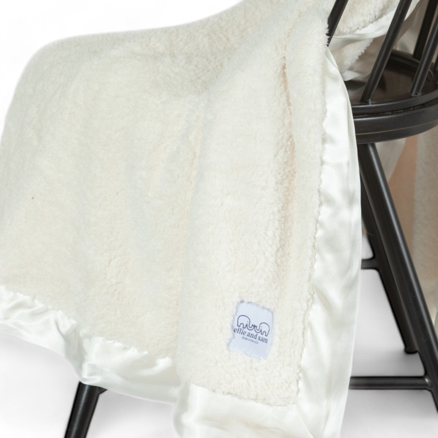 Ivory chenille throw blanket draped on chair, soft plush blanket with satin trim